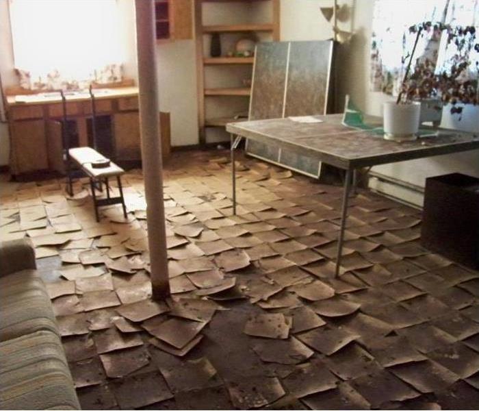 dirty floor, uplifted vinyl tiles, before cleanup