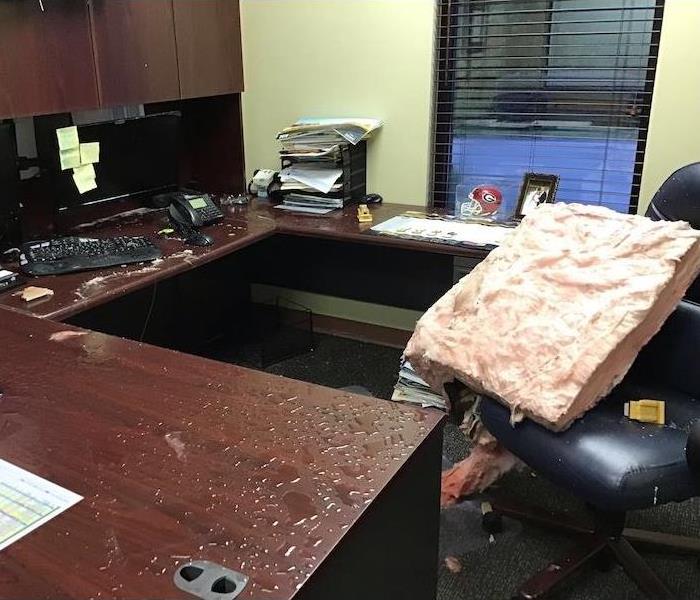 Water damaged office with a wet office, chair, and desktop items