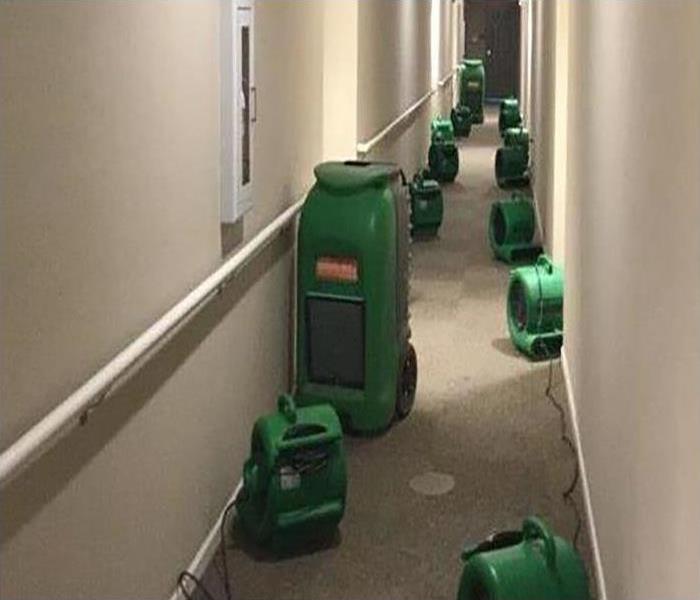 drying equipment lining the hallway after a water damage disaster